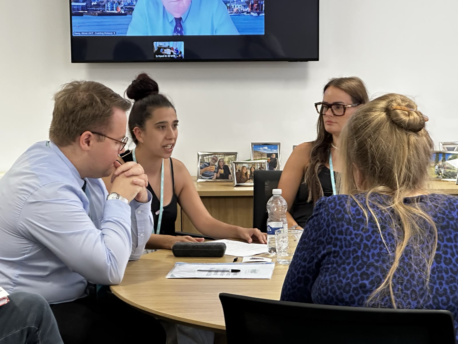 Meeting participants discussing care-experienced young people's priorities around a table